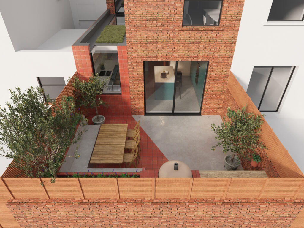 View of the rear extension and patio of Ice Cream House, the polished concrete floor continues from inside to outside with the seating area of the patio being tiled in terracotta tiles that wrap up the face of the side extension
