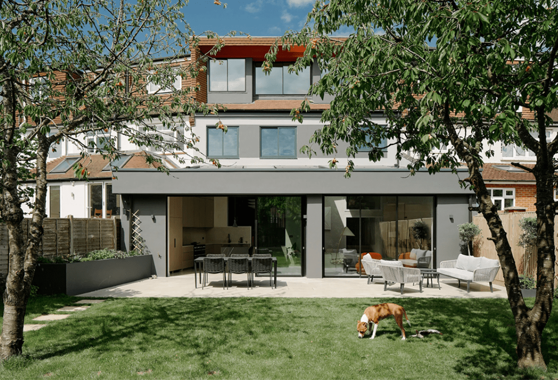 A modern rear home extension with sliding glass doors and outdoor seating, showcasing how advanced technology allows clients to collaborate in real-time with architects to personalise designs, blending aesthetics with functionality.