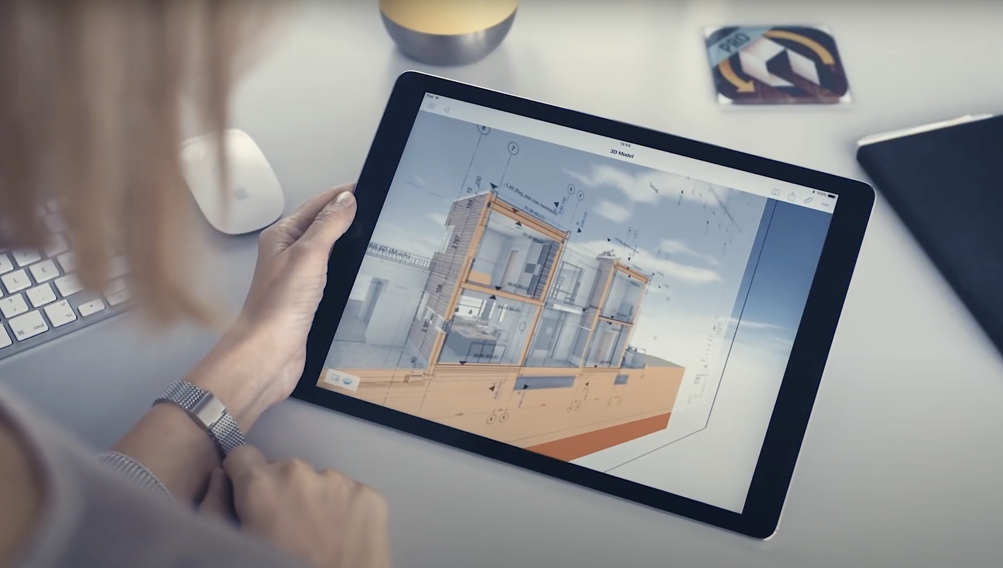 Architect using a tablet to view a 3D building model in BIMx Archicad, showcasing detailed architectural designs and annotations.