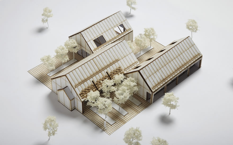 An architects model of a yoga retreat made with light wood and card